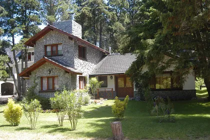Fachada rústica de piedra y madera en bosque — proyecto Casa Cariló 2003 - 2, por Hugo Zawadski Arquitectos, en Cariló