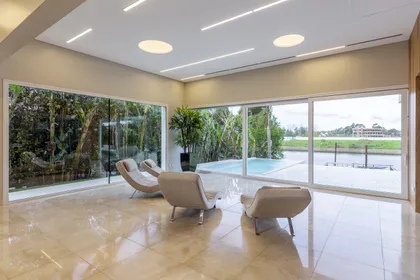 Living moderno con vista al bosque y piscina — proyecto Las Caletas, por Arfuso Arquitectos, en Nordelta