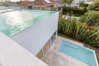 pileta infinity con borde de vidrio y deck de madera — proyecto Las Caletas, por Arfuso Arquitectos, en Nordelta