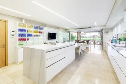 Cocina moderna con isla grande de mármol y comedor integrado — proyecto Las Caletas, por Arfuso Arquitectos, en Nordelta