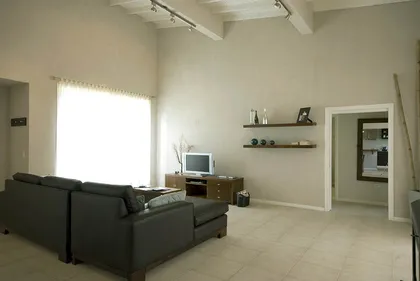 Living moderno con techo doble altura y vigas a la vista — proyecto Casa Cariló 2007, por Hugo Zawadski Arquitectos, en Cariló