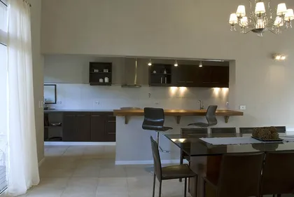 Cocina y comedor modernos de concepto abierto con isla — proyecto Casa Cariló 2007, por Hugo Zawadski Arquitectos, en Cariló
