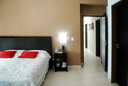 Dormitorio moderno con cama, pared texturizada y luces indirectas — proyecto Casa El Recodo, por Fhee Construcciones, en Garin