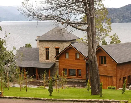 casa moderna rústica con fachada de madera y piedra en montaña — proyecto Corrientes del Nahuel, por Ricardo Pereyra Iraola , en Bariloche