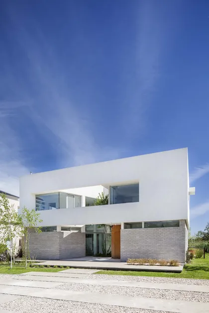 fachada moderna con ventanas amplias y ladrillos grises — proyecto Casa MA, por Estudio GR, en City Bell