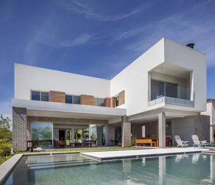 Fachada moderna con piscina y sala de estar exterior — proyecto Casa MA, por Estudio GR, en City Bell