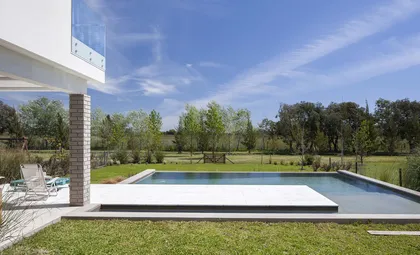 Piscina moderna con deck blanco y césped exuberante — proyecto Casa MA, por Estudio GR, en City Bell