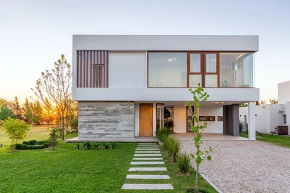 Fachada moderna con revestimiento de piedra y madera — proyecto Casa ME, por Estudio GR, en City Bell