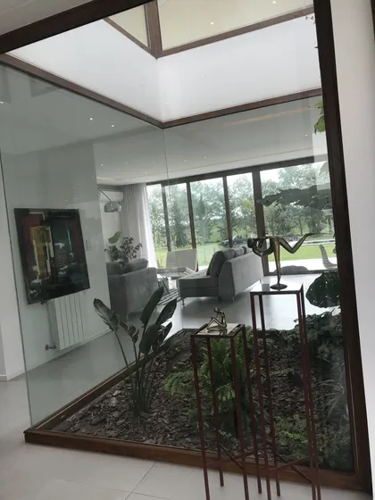 Living moderno con jardín interior y techos altos — proyecto Casa ME, por Estudio GR, en City Bell