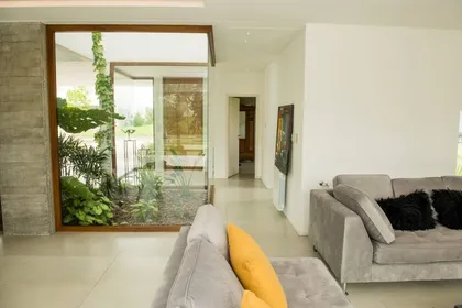 Living moderno con patio interior y mucha vegetación — proyecto Casa ME, por Estudio GR, en City Bell