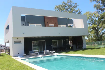 Fachada moderna con piscina y muebles de exterior — proyecto Golondrinas 98, por Marcela Romiti Arquitectura, en La Plata