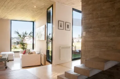 Living moderno con hormigón visto y grandes ventanales — proyecto casa lc, por GARAGE arquitectura, en Mar del Plata