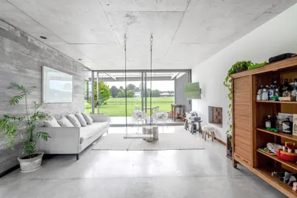 Living moderno con sillones colgantes y hormigón expuesto — proyecto casa r, por GARAGE arquitectura, en Mar del Plata