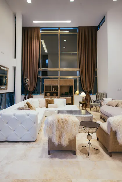 Living moderno con ventanal doble altura y sofá blanco — proyecto Grand Bell 60, por Mercedes  klappenbach, en City Bell