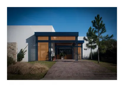Fachada moderna con pérgola de madera y camino de ladrillos — proyecto Los Ceibos 60, por Mercedes  klappenbach, en La Plata