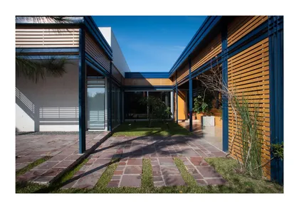 fachada moderna con pérgola de madera y detalles azules — proyecto Los Ceibos 60, por Mercedes  klappenbach, en La Plata