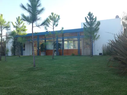 fachada moderna con ventanales y jardín — proyecto Los Ceibos 60, por Mercedes klappenbach, en La Plata