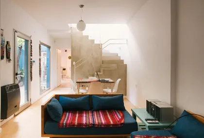 Living moderno con detalles boho y escalera flotante — proyecto Calle 67, por Mercedes klappenbach, en La Plata