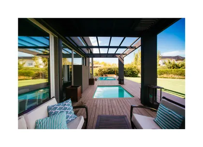 Patio moderno con piscina, deck de madera y pérgola — proyecto Grand Bell 98, por Mercedes  klappenbach, en City Bell