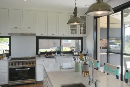 Cocina moderna blanca con isla central y ventanales grandes — proyecto Casa 16, por Parrado Arquitectura