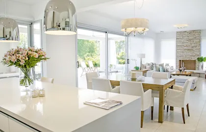 Cocina moderna blanca con isla de mármol y amplios ventanales — proyecto Casa 13, por Parrado Arquitectura