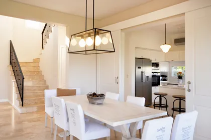 Comedor blanco moderno con escalera de madera y doble altura — proyecto Casa 12, por Parrado Arquitectura