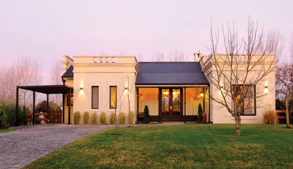 Casa moderna con fachada beige, amplia terraza y jardín al atardecer — proyecto Casa 8, por Parrado Arquitectura