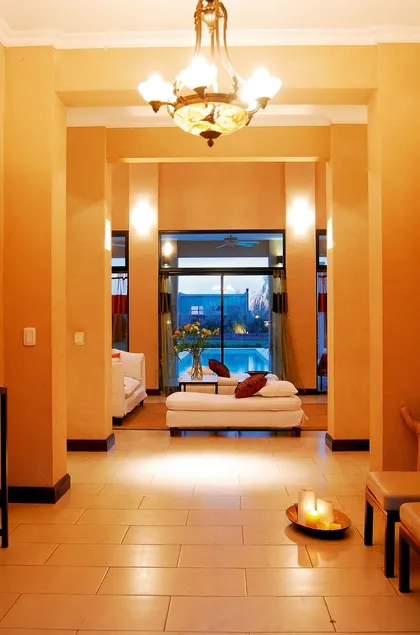 Pasillo iluminado con paredes terracota y ventanal con vista nocturna — proyecto Casa 2, por Parrado Arquitectura