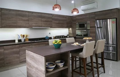 Cocina moderna con isla de madera, muebles gris oscuro y accesorios cobre — proyecto SD 48, por Estudio Arq Daniel Tarrio
