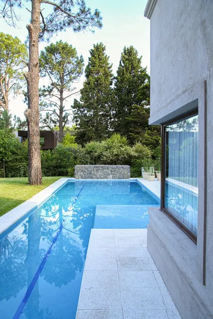 Pileta moderna junto a casa con deck y vistas al jardín arbolado — proyecto SD 48, por Estudio Arq Daniel Tarrio