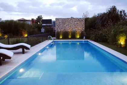 Pileta rectangular de diseño moderno con iluminación nocturna y jardinería — proyecto VO 38, por Estudio Arq Daniel Tarrio