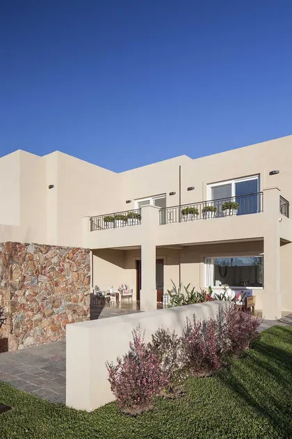 Casa contemporánea blanca con balcones, terraza y jardín verde — proyecto TRV 137, por Estudio Arq Daniel Tarrio