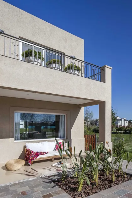 Patio moderno con cama y plantas junto a fachada blanca — proyecto TRV 137, por Estudio Arq Daniel Tarrio