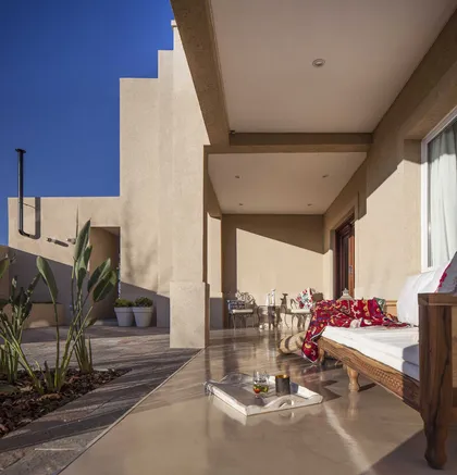 Terraza cubierta moderna con piso hormigonado, plantas y flores rojas — proyecto TRV 137, por Estudio Arq Daniel Tarrio