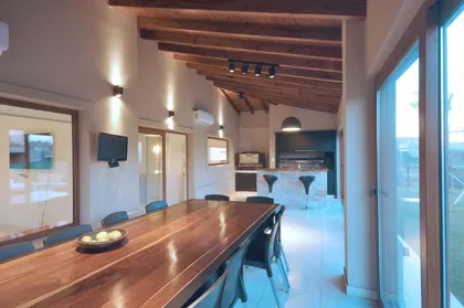 Comedor moderno con mesa de madera y vistas panorámicas amplias — proyecto TRV 195, por Estudio Arq Daniel Tarrio