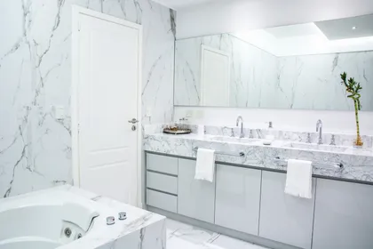 Baño moderno con mármol Carrara, mesada doble y espejo empotrado — proyecto TRV 620, por Estudio Arq Daniel Tarrio