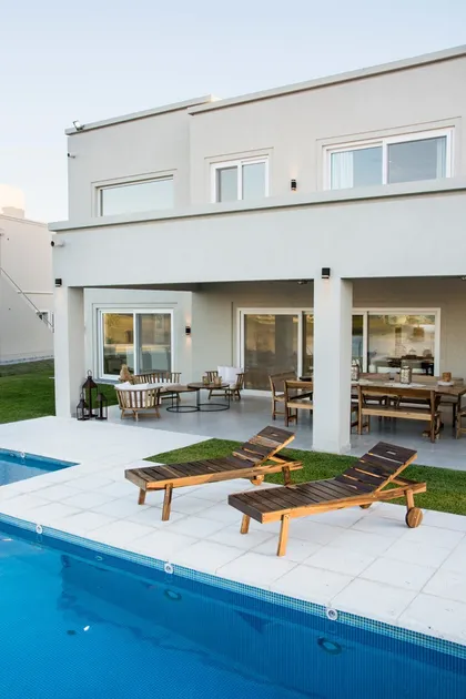 Casa moderna con patio, pileta y reposeras de madera natural — proyecto TRV 620, por Estudio Arq Daniel Tarrio