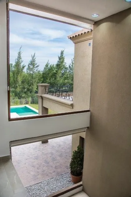 Vista desde balcon interior hacia terraza, piscina y arboleda — proyecto TRV 81, por Estudio Arq Daniel Tarrio