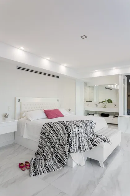 Dormitorio blanco minimalista con baño integrado y pisos de mármol — proyecto TRV 490, por Estudio Arq Daniel Tarrio