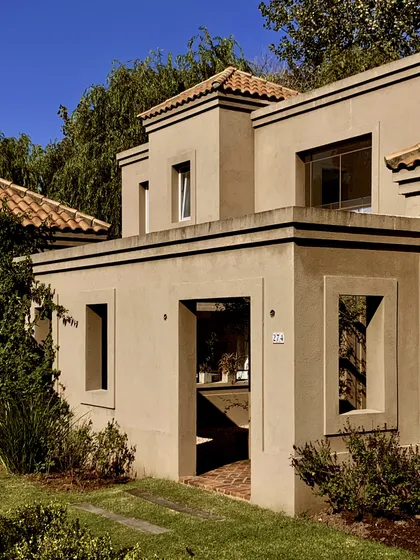 Casa dos plantas con fachada beige, franjas negras y techo cerámico — proyecto El Encuentro , por Marconi Silva Arquitectos, en Benavidez