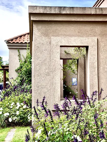 Casa mediterránea con fachada de hormigón y lavanda púrpura en primer plano — proyecto El Encuentro , por Marconi Silva Arquitectos, en Benavidez