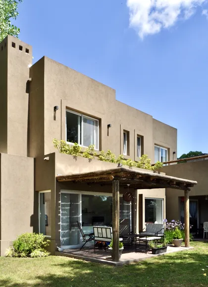 Casa moderna de hormigón con pergola de madera y galería vidriada — proyecto El Encuentro  2, por Marconi Silva Arquitectos, en Benavidez