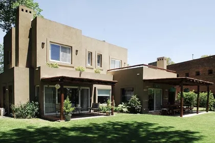 Casa contemporánea con patio amplio, jardín y pérgola lateral — proyecto El Encuentro  2, por Marconi Silva Arquitectos, en Benavidez
