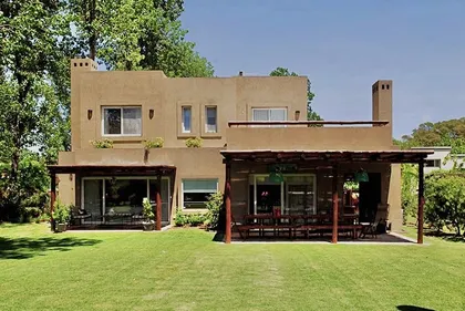 Casa contemporánea beige con galería cubierta y jardín verde amplio — proyecto El Encuentro  2, por Marconi Silva Arquitectos, en Benavidez