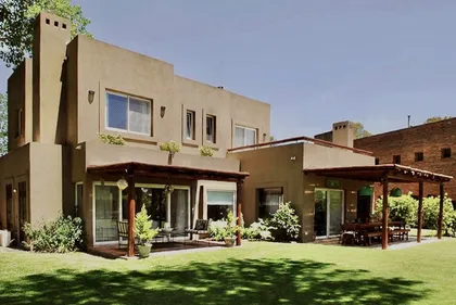 Casa contemporánea con patio amplio, pergolado y jardín verde — proyecto El Encuentro  2, por Marconi Silva Arquitectos, en Benavidez