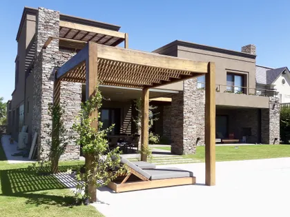Casa moderna con patio y pergola de madera sobre deck — proyecto Golf Club Nordelta, por Marconi Silva Arquitectos, en Nordelta