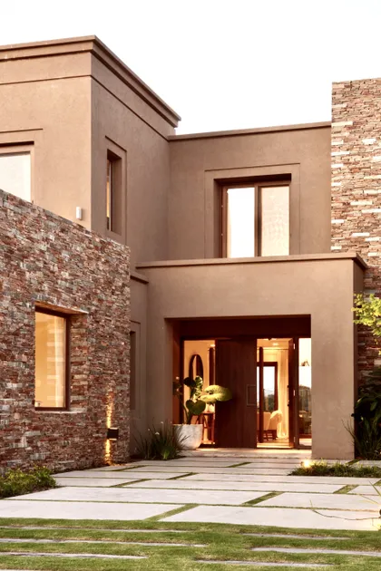 Casa moderna dos pisos fachada ladrillo visto y hormigón — proyecto Golf Club Nordelta, por Marconi Silva Arquitectos, en Nordelta
