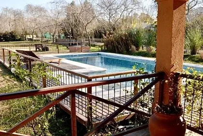 Pileta rectangular con pergola de madera y barandas de hierro — proyecto La Retama, por Marconi Silva Arquitectos, en Manzanares