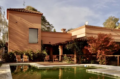 Casa contemporanea terracota con pileta y vegetacion exuberante — proyecto La Retama, por Marconi Silva Arquitectos, en Manzanares