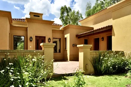 Casa color beige con pergola, jardineras y plantas verdes — proyecto La Retama 2, por Marconi Silva Arquitectos, en Manzanares